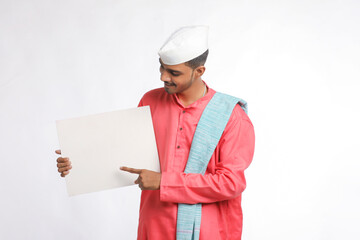Young indian farmer holding white card board on white background.