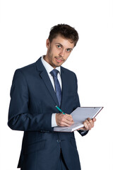 Portrait of handsome young businessman holding diary on a white background. Holds a notebook and writes information, tasks, reminders. He is wearing elegant suit.