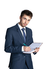 Portrait of handsome young businessman holding diary on a white background. Holds a notebook and writes information, tasks, reminders. He is wearing elegant suit.