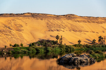 Early morning view of the Nile River and sand dunes in Aswan, Egypt