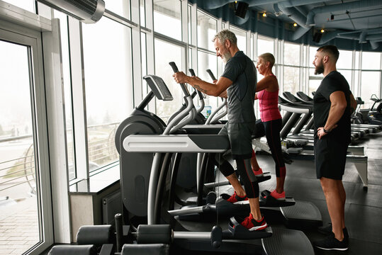 Active mature couple exercising together at gym