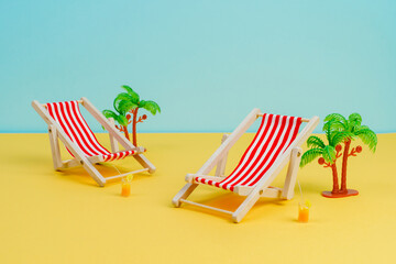 Sun loungers stand on a yellow background. Concept photo