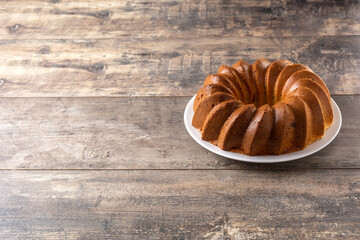 Traditional bundt cake piece with raisins on wooden table. Copy space