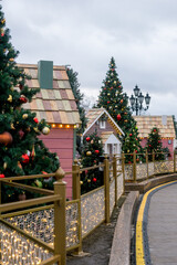 Christmas decorative houses on a festive city street (small wooden houses among Christmas trees).