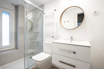 Modern bathroom with furniture and white sink with round mirror