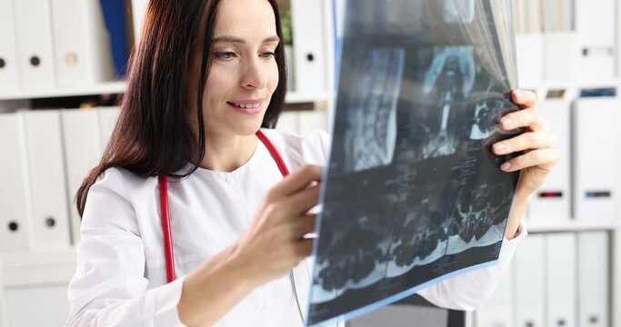Woman doctor looking at xray of spine in clinic 4k movie slow motion