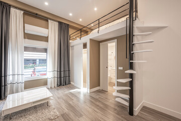 Living room in a loft with raised bedroom with white steps staircase