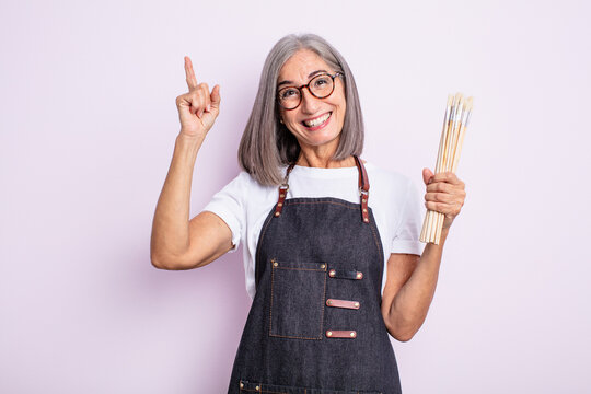 senior pretty woman feeling like a happy and excited genius after realizing an idea. artist with brushes