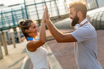 Happy runner couple exercising outside as part of healthy lifestyle. People sport running concept