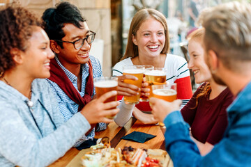 Group of diverse young friends enjoying a beer together