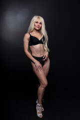Fashionable photo of young blonde woman wearing black lingerie 