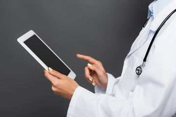 Cropped view of doctor holding digital tablet with blank screen isolated on grey
