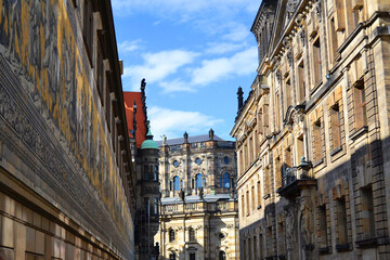 Fototapeta na wymiar Augustus Street in Dresden, Saxony, Germany. Furstenzug giant mural decorates mosaic on the wall on the left and Dresden Cathedral, or the Cathedral of the Holy Trinity in the middle.