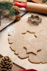 Fototapeta na wymiar Homemade Christmas biscuits. Dough and cookie cutter on table, closeup