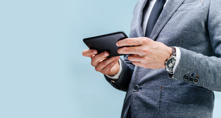 A man in a suit holds a phone