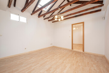 Living room in an empty apartment with exposed wooden beams