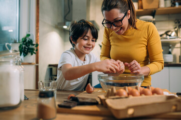 mother and son preparing food in kitchen