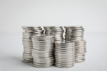 Many silver coins stacked on white table