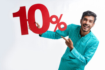 Indian man holding ten percent sign board promoting offers on festival season while wearing traditional cloths.