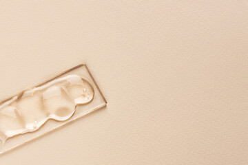 A smear of a clear liquid cosmetic product on a glass surface. Beauty and medicine concept. Top view, copy space