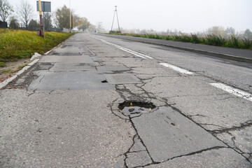 Fused and damaged asphalt road suitable for renovation and posing a threat.