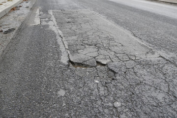 Fused and damaged asphalt road suitable for renovation and posing a threat.