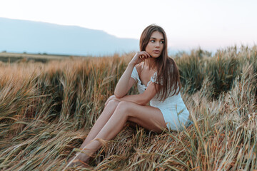 sexy girl sitting in a wheat field