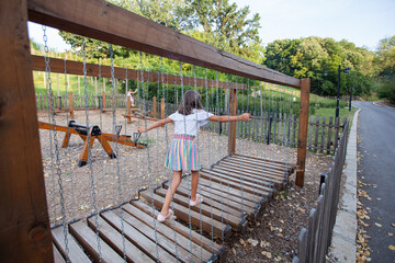 Fototapeta na wymiar Little girl fun at playground on summer day.