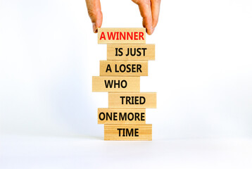 Winner or loser symbol. Wooden blocks with words A winner is just a loser who tried one more time. Beautiful white background, copy space. Businessman hand. Business, winner or loser concept.