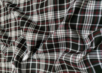 Gray tartan woolen school uniform fabric material. Scottish classic seamless flannel cloth. Traditional wave pattern for a Christmas background or wallpaper. Black, Green, Red and White checkered.