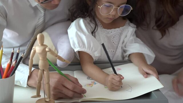 Asian family, parent teaching their daughter a homework.