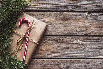 Christmas gifts for new year wrapped in craft paper near branches and cones on wooden background