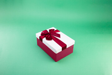 red gift box with ribbon on a green background