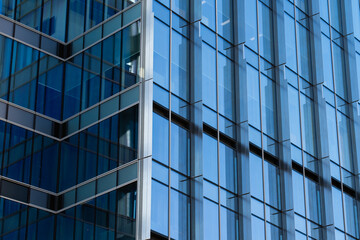 Fototapeta na wymiar Modern glass architecture of an office building windows close up in blue colors 