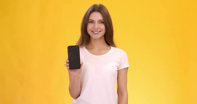Everything's in your phone. Positive young caucasian lady showing modern mobile phone with blank screen
