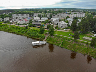 Aerial view of a small boat docked on the bank of the Vyatka river (Murygino, Kirov region, Russia)