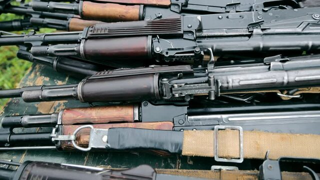 storage of a large number of weapons, submachine guns and rifles. Panorama of a weapon lying on a wooden box.