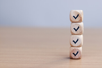 Check mark on wooden cube, checklist concept