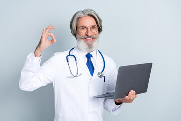 Photo of senior man cardiologist consultation use laptop show fingers okey symbol perfect ad...