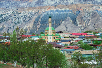 Fototapeta na wymiar Mosque in spring in an authentic mountain village. Mosque in the center of a mountain village. Landscape and countryside of cityscape in Salta. Dagestan.