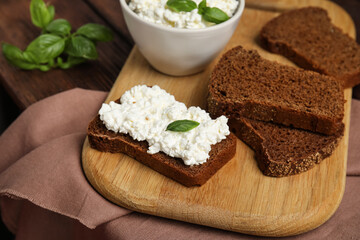 Bread with cottage cheese and basil on table