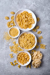 Mix of Italian raw pasta in white bowls