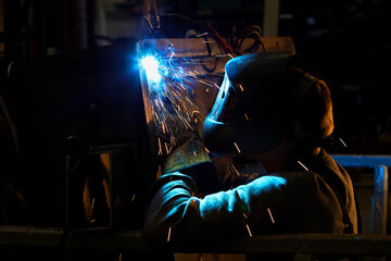 Industrial welder worker at factory welding steel