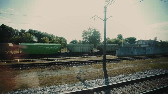 Traveling by train. A passenger train passes by a small industrial town. Transport connection. Railroad crossing. Tourism.