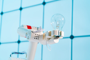 Lighting retro electric bulb lamp in a robot hand