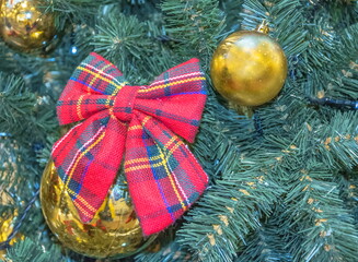 Original Christmas tree decoration in the form of a bright red checkered bow
