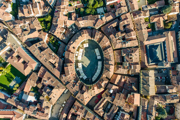 Aerial view of Piazza dell'Anfiteatro, a medieval square with cafè and market in Lucca old town, Tuscany, Italy.