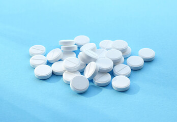 Antiviral white tablets for treatment on a blue background. Flat lay, top view