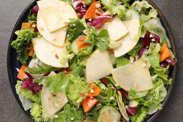 Delicious turnip salad served on grey table, top view