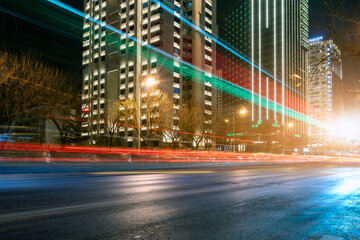 Night view of traffic light and shadow trails in urban financial district streets